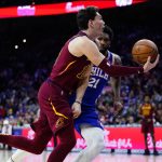 
              Cleveland Cavaliers' Cedi Osman, left, goes up for a shot against Philadelphia 76ers' Joel Embiid during the first half of an NBA basketball game, Friday, March 4, 2022, in Philadelphia. (AP Photo/Matt Slocum)
            