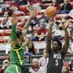 Washington State guard TJ Bamba, right, shoots while defended by Oregon guard Rivaldo Soares during the second half of an NCAA college basketball game, Saturday, March 5, 2022, in Pullman, Wash. Washington State won 94-74. (AP Photo/Young Kwak)