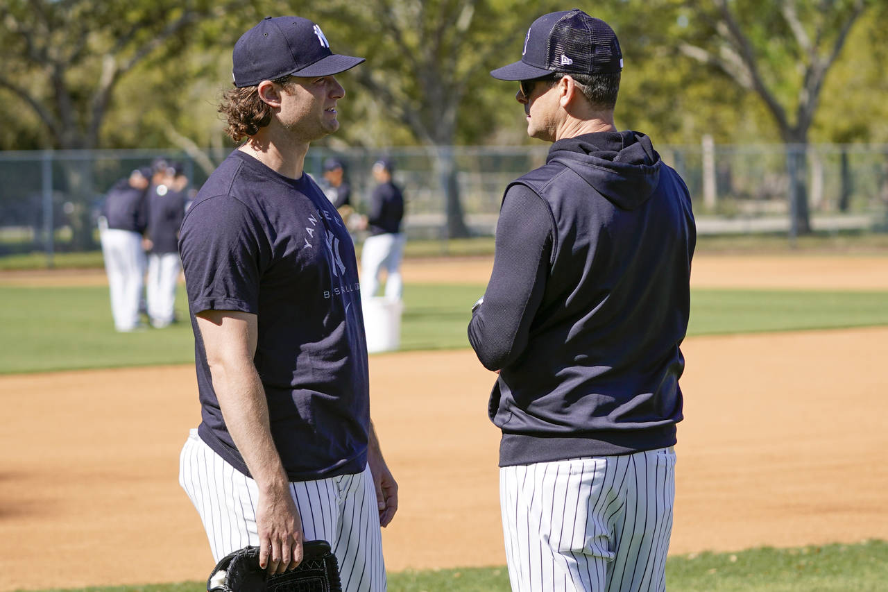 New York Yankees pitcher Gerrit Cole, left, talks with manager Aaron Boone during a spring training...