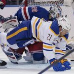 
              Buffalo Sabres' Kyle Okposo (21), right, falls over New York Rangers goaltender Alexandar Georgiev (40) as he scores a goal during the second period of the NHL hockey game, Sunday, March 27, 2022, in New York. (AP Photo/Seth Wenig)
            