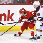 
              Edmonton Oilers' Leon Draisaitl, right, from Germany, battles for the puck with Calgary Flames' Johnny Gaudreau during second-period NHL hockey game action in Calgary, Alberta, Monday, March 7, 2022. (Larry MacDougal/The Canadian Press via AP)
            
