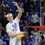 
              Kansas' Mitch Lightfoot cuts down the net after a college basketball game in the Elite 8 round of the NCAA tournament Sunday, March 27, 2022, in Chicago. Kansas won 76-50 to advance to the Final Four. (AP Photo/Charles Rex Arbogast)
            