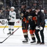 
              Anaheim Ducks center Isac Lundestromm second from right is helped off the ice after being injured during the first period of an NHL hockey game against the San Jose Sharks Sunday, March 6, 2022, in Anaheim, Calif. (AP Photo/Mark J. Terrill)
            