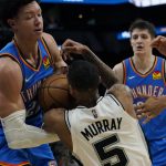 
              Oklahoma City Thunder forward Isaiah Roby (22) and San Antonio Spurs guard Dejounte Murray (5) scramble for a loose ball during the second half of an NBA basketball game, Wednesday, March 16, 2022, in San Antonio. (AP Photo/Eric Gay)
            