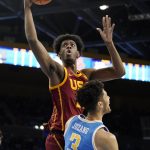 
              Southern California forward Joshua Morgan, left, shoots as UCLA guard Johnny Juzang defends during the first half of an NCAA college basketball game Saturday, March 5, 2022, in Los Angeles. (AP Photo/Mark J. Terrill)
            