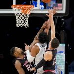 
              Virginia's Jayden Gardner (1) shoots against Louisville's Sydney Curry (21) and Samuell Williamson (10) in the first period of an NCAA college basketball game during the Atlantic Coast Conference men's tournament, Wednesday, March 9, 2022, in New York. (AP Photo/John Minchillo)
            