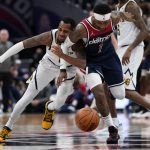 
              Denver Nuggets guard Monte Morris, left, and Washington Wizards guard Kentavious Caldwell-Pope fight for a loose ball during the first half of an NBA basketball game, Wednesday, March 16, 2022, in Washington. (AP Photo/Evan Vucci)
            