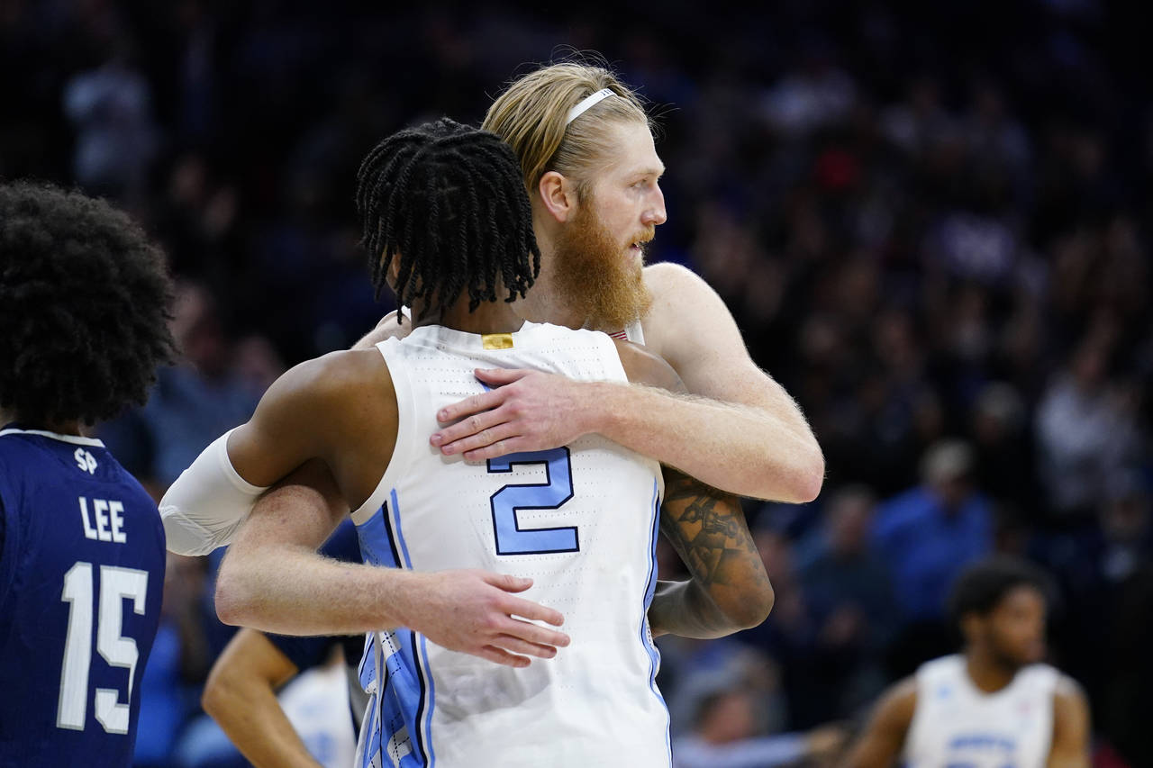 North Carolina's Brady Manek, right, and Caleb Love embrace during the second half of a college bas...