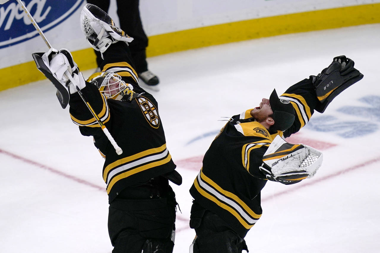 Boston Bruins goaltender Linus Ullmark, left, celebrates with goaltender Jeremy Swayman after the B...