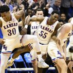 
              Kansas guard Ochai Agbaji (30), guard Jalen Coleman-Lands (55) and forward Zach Clemence (21) celebrate after defeating Texas during overtime in an NCAA college basketball game in Lawrence, Kan., Saturday, March 5, 2022. (AP Photo/Reed Hoffmann)
            