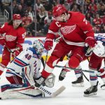 
              New York Rangers goaltender Alexandar Georgiev (40) stops a shot as Detroit Red Wings center Dylan Larkin (71) jumps to clear space for the shot in the second period of an NHL hockey game Wednesday, March 30, 2022, in Detroit. (AP Photo/Paul Sancya)
            