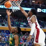 
              Vermont guard Ben Shungu (24) shoots against Arkansas guard Stanley Umude (0) during the first half of a college basketball game in the first round of the NCAA men's tournament Thursday, March 17, 2022, in Buffalo, N.Y. (AP Photo/Frank Franklin II)
            