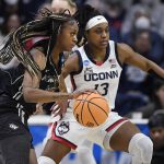 
              Central Florida's Tay Sanders, left, dribbles around Connecticut's Christyn Williams during the first half of a second-round women's college basketball game in the NCAA tournament, Monday, March 21, 2022, in Storrs, Conn. (AP Photo/Jessica Hill)
            