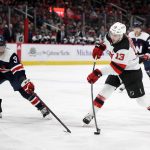 
              New Jersey Devils center Nico Hischier (13) shoots against Washington Capitals defenseman Nick Jensen (3) during the second period of an NHL hockey game, Saturday, March 26, 2022, in Washington. (AP Photo/Nick Wass)
            