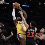 
              Los Angeles Lakers' LeBron James, center, left, goes up for a basket under pressure by Toronto Raptors' Fred VanVleet (23) during first half of an NBA basketball game Monday, March 14, 2022, in Los Angeles. (AP Photo/Jae C. Hong)
            