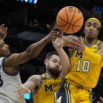 
              Villanova forward Jermaine Samuels, left, and and Michigan center Hunter Dickinson (1) and guard Frankie Collins vie for a loose ball during the first half of a college basketball game in the Sweet 16 round of the NCAA tournament on Thursday, March 24, 2022, in San Antonio. (AP Photo/Eric Gay)
            
