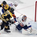 
              Boston Bruins' Craig Smith (12) scores on New York Islanders' Semyon Varlamov (40) during the first period of an NHL hockey game, Saturday, March 26, 2022, in Boston. (AP Photo/Michael Dwyer)
            