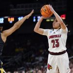 
              Louisville guard Chelsie Hall (23) shoots on Michigan guard Laila Phelia (5) during the first half of a college basketball game in the Elite 8 round of the NCAA women's tournament Monday, March 28, 2022, in Wichita, Kan. (AP Photo/Jeff Roberson)
            