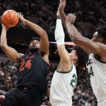 
              Maryland forward Donta Scott (24) is defended by Michigan State forward Malik Hall, center, and forward Julius Marble II during the first half of an NCAA college basketball game, Sunday, March 6, 2022, in East Lansing, Mich. (AP Photo/Carlos Osorio)
            