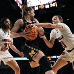 
              Michigan guard Danielle Rauch (23) tries to protect the ball from Louisville forward Emily Engstler (21) during the second half of a college basketball game in the Elite 8 round of the NCAA women's tournament Monday, March 28, 2022, in Wichita, Kan. (AP Photo/Jeff Roberson)
            
