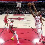 
              Chicago Bulls' Ayo Dosunmu, drives to the basket and scores past Toronto Raptors' Scottie Barnes during the first half of an NBA basketball game Monday, March 21, 2022, in Chicago. (AP Photo/Charles Rex Arbogast)
            