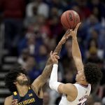 
              Kansas forward Jalen Wilson (10) shoots over West Virginia forward Isaiah Cottrell (13) during the first half of an NCAA college basketball game in the quarterfinal round of the Big 12 Conference tournament in Kansas City, Mo., Thursday, March 10, 2022. (AP Photo/Charlie Riedel)
            