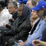 
              Kanye West, middle, watches during the first half of an NBA basketball game between the Golden State Warriors and the Boston Celtics in San Francisco, Wednesday, March 16, 2022. (AP Photo/Jeff Chiu)
            