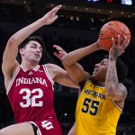 
              Michigan guard Eli Brooks (55) shoots over Indiana guard Trey Galloway (32) in the second half of an NCAA college basketball game at the Big Ten Conference tournament in Indianapolis, Thursday, March 10, 2022. Indiana defeated Michigan 74-69. (AP Photo/Michael Conroy)
            