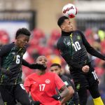 
              Jamaica's Ravel Morrison heads the ball as teammate Richard King and Canada's Cyle Larin look on during the first half of a CONCACAF World Cup soccer qualifying match in Toronto on Sunday, March 27, 2022. (Frank Gunn/The Canadian Press via AP)
            