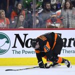 
              Philadelphia Flyers' Kevin Connauton tries to stand up after a hit from Chicago Blackhawks' Kirby Dach during the third period of an NHL hockey game, Saturday, March 5, 2022, in Philadelphia. (AP Photo/Derik Hamilton)
            