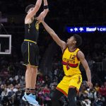 
              Golden State Warriors guard Klay Thompson, left, shoots over Atlanta Hawks forward De'Andre Hunter (12) during the second half of an NBA basketball game Friday, March 25, 2022, in Atlanta. (AP Photo/Hakim Wright Sr.)
            