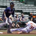 
              Baltimore Orioles' Cedric Mullins (31) slides into third base as Minnesota Twins third baseman Jose Miranda, left, waits for the throw in the second inning of a spring training baseball game Monday, March 21, 2022, in Sarasota, Fla. (AP Photo/Steve Helber)
            