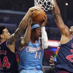 
              Los Angeles Clippers guard Terance Mann, center, tries to pass the ball while under pressure from Philadelphia 76ers forward Danny Green, left, and center Joel Embiid during the first half of an NBA basketball game Friday, March 25, 2022, in Los Angeles. (AP Photo/Mark J. Terrill)
            