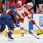 
              Calgary Flames left wing Matthew Tkachuk, right, passes the puck as Colorado Avalanche's Devon Toews defends during the second period of an NHL hockey game Saturday, March 5, 2022, in Denver. (AP Photo/David Zalubowski)
            