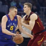 
              Denver Nuggets' Nikola Jokic (15) drives against Cleveland Cavaliers' Lauri Markkanen, right, during the first half of an NBA basketball game, Friday, March 18, 2022, in Cleveland. (AP Photo/Ron Schwane)
            