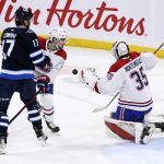 
              Montreal Canadiens goaltender Sam Montembeault (35) makes save as Winnipeg Jets' Adam Lowry (17) looks for the rebound during the second period of an NHL hockey game Tuesday, March 1, 2022, in Winnipeg, Manitoba. (Fred Greenslade/The Canadian Press via AP)
            