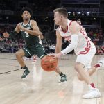 
              Wisconsin's Brad Davison, right, goes to the basket against Michigan State's Jaden Akins (3) during the first half of an NCAA college basketball game at the Big Ten Conference tournament, Friday, March 11, 2022, in Indianapolis. (AP Photo/Darron Cummings)
            