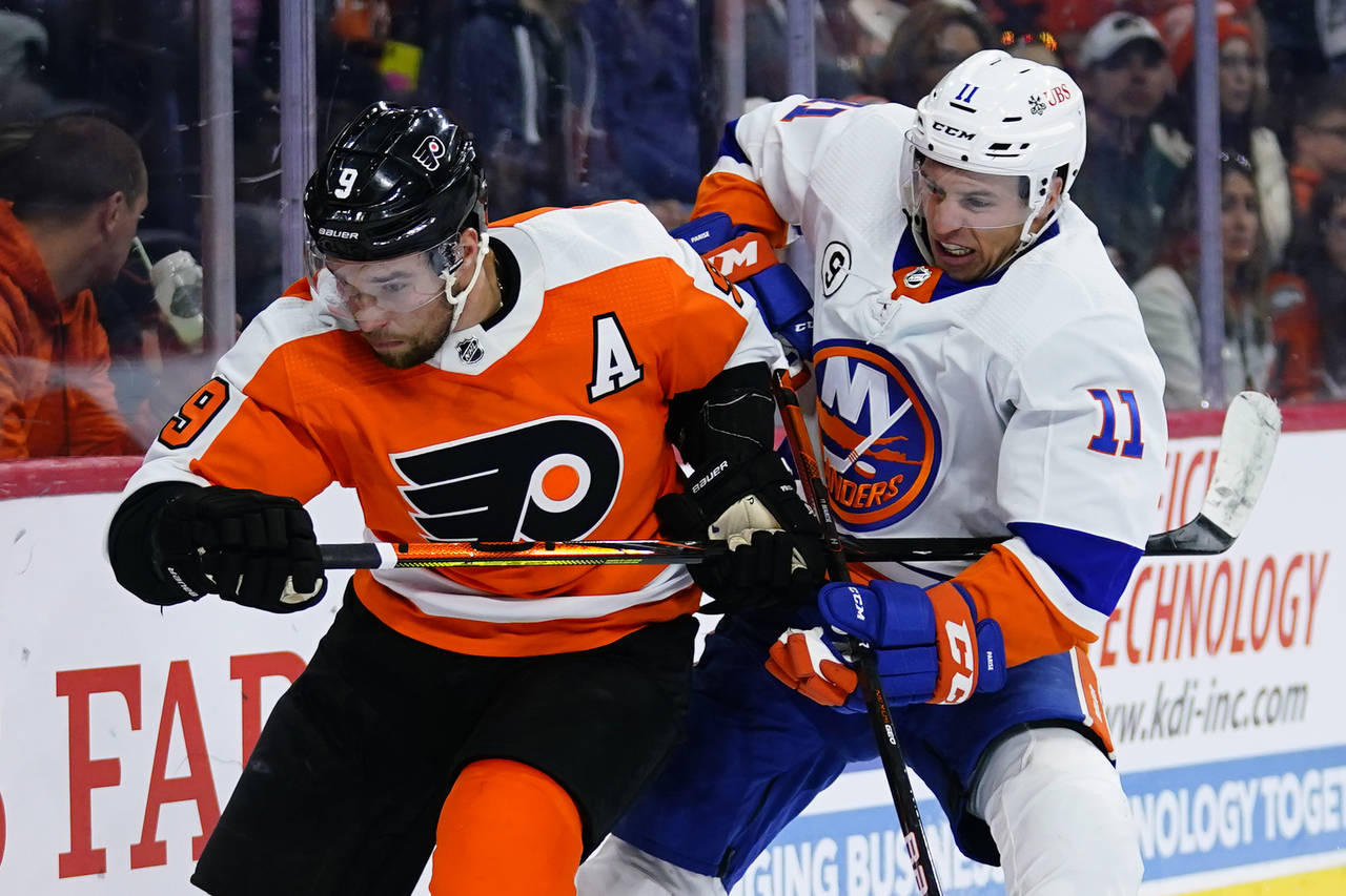 Philadelphia Flyers' Ivan Provorov, left, and New York Islanders' Zach Parise battle for position d...