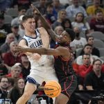 
              Villanova guard Collin Gillespie passes around Houston guard Jamal Shead during the first half of a college basketball game in the Elite Eight round of the NCAA tournament on Saturday, March 26, 2022, in San Antonio. (AP Photo/David J. Phillip)
            