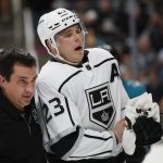 
              Los Angeles Kings head athletic trainer Chris Kingsley, left, escort right wing Dustin Brown (23) during the second period of an NHL hockey game against the San Jose Sharks in San Jose, Calif., Saturday, March 12, 2022. (AP Photo/Josie Lepe)
            