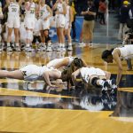 
              Michigan players, clockwise from top right, forward Naz Hillmon, guard Amy Dilk, guard Danielle Rauch and forward Emily Kiser kiss the mid-court logo after the second half of a college basketball game in the second round of the NCAA tournament against Villanova, Monday, March 21, 2022, in Ann Arbor, Mich. The seniors played their last home game at Crisler Arena. (AP Photo/Carlos Osorio)
            
