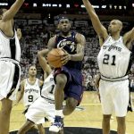 
              FILE - Cleveland Cavaliers forward LeBron James (23) drives past San Antonio Spurs forward Tim Duncan (21) and San Antonio Spurs forward Robert Horry, left, in the second half of Game 1 of the NBA Finals basketball game in San Antonio, June 7, 2007. (AP Photo/Tony Dejak, File)
            