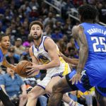 
              Golden State Warriors guard Klay Thompson, center, looks to pass the ball as he is caught between Orlando Magic guard Markelle Fultz, left, and forward Admiral Schofield (25) during the first half of an NBA basketball game, Tuesday, March 22, 2022, in Orlando, Fla. (AP Photo/John Raoux)
            