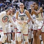 
              Connecticut's Nika Mühl (10) is congratulated by her teammates as she is awarded Big East Defensive Player of the Year before an NCAA college basketball game against Georgetown in the Big East tournament quarterfinals at Mohegan Sun Arena, Saturday, March 5, 2022, in Uncasville, Conn. (AP Photo/Jessica Hill)
            