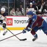 
              Edmonton Oilers center Leon Draisaitl, left, shoots the puck past Colorado Avalanche right wing Nicolas Aube-Kubel in the second period of an NHL hockey game Monday, March 21, 2022, in Denver. (AP Photo/David Zalubowski)
            