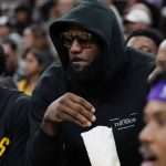 
              Los Angeles Lakers forward LeBron James eats a snack while on the bench during the first half of an NBA basketball game against the San Antonio Spurs, Monday, March 7, 2022, in San Antonio. James did not play. (AP Photo/Eric Gay)
            