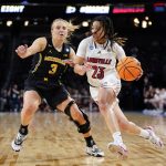 
              Louisville guard Chelsie Hall (23) drives on Michigan guard Maddie Nolan (3) during the first half of a college basketball game in the Elite 8 round of the NCAA women's tournament Monday, March 28, 2022, in Wichita, Kan. (AP Photo/Jeff Roberson)
            