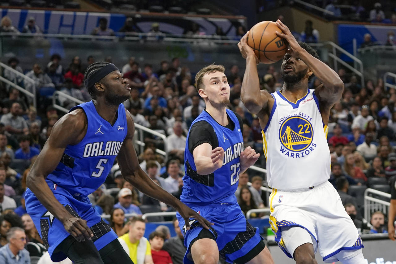 Golden State Warriors forward Andrew Wiggins, right, looks for a shot against Orlando Magic forward...