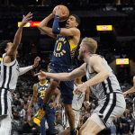 
              Indiana Pacers' Tyrese Haliburton (0) drives between San Antonio Spurs' Tre Jones, left, and Jock Landale, right, during the first half of an NBA basketball game in San Antonio, Saturday, March 12, 2022. (AP Photo/Chuck Burton)
            