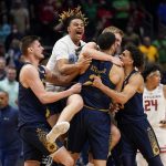 
              Notre Dame players celebrate after defeating Rutgers 89-87 in double overtime in a First Four game in the NCAA men's college basketball tournament, early Thursday, March 17, 2022, in Dayton, Ohio. (AP Photo/Jeff Dean)
            
